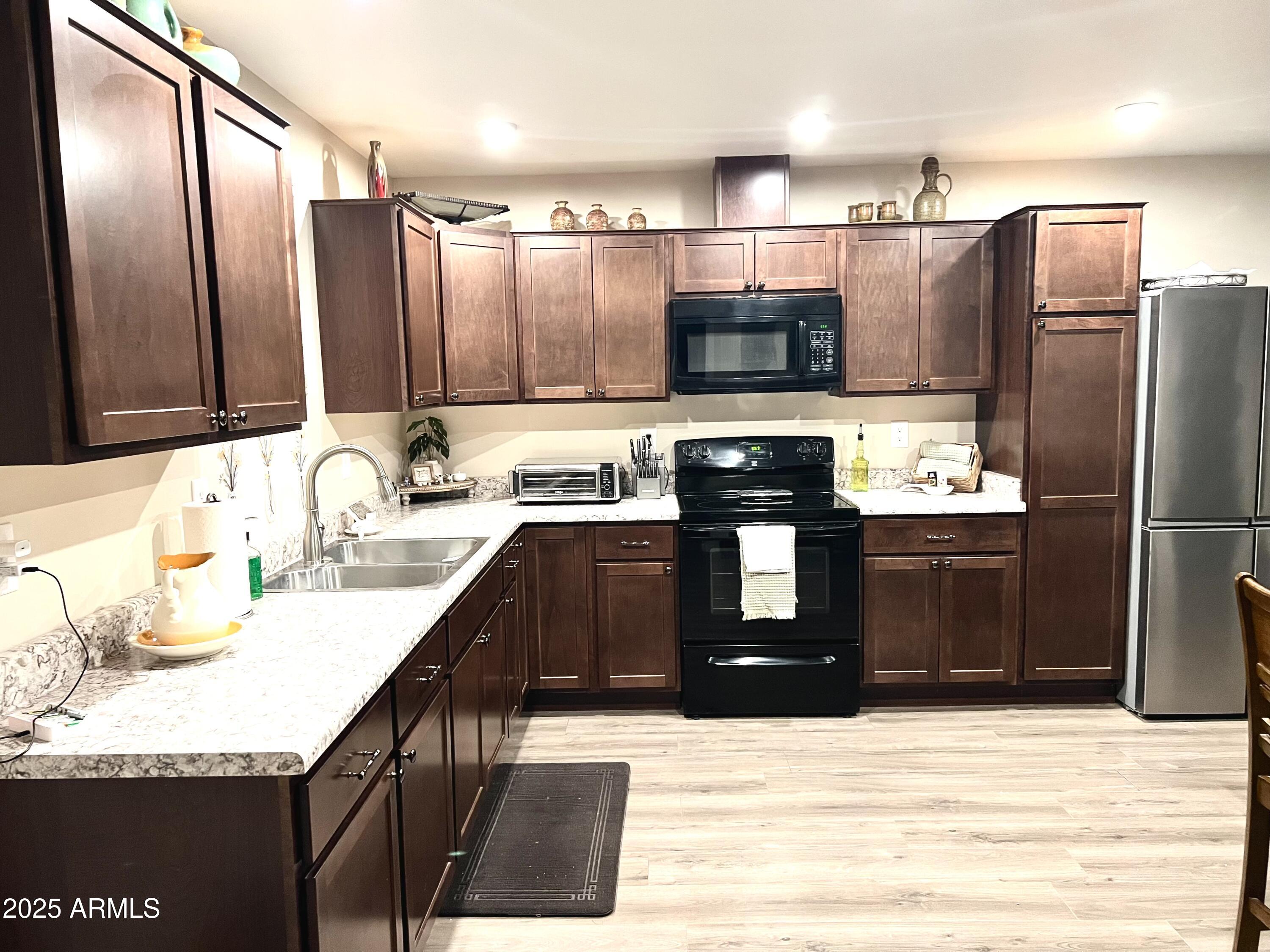 311 Solana Avenue Ajo, AZ 85321 - Photo 6 of 22 a kitchen with stainless steel appliances kitchen island granite countertop a refrigerator a stove and a sink