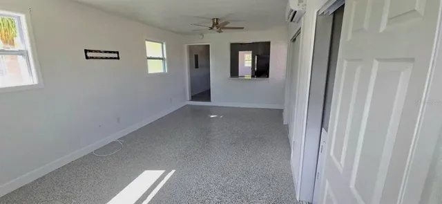 an empty room with windows and cabinet