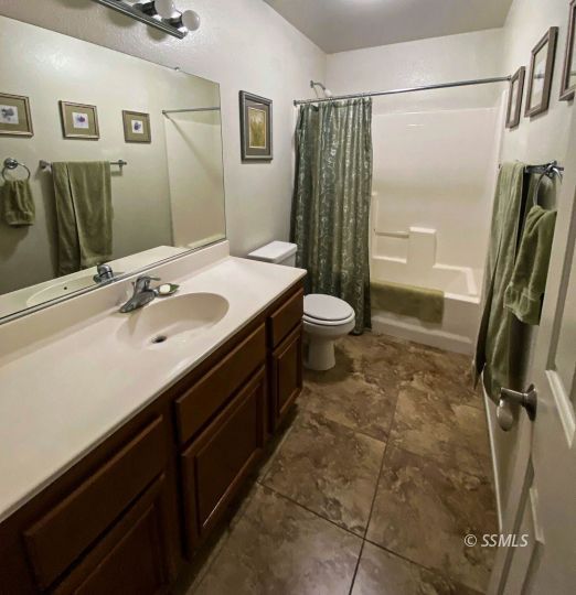 1109 Rebecca Avenue Ridgecrest, CA 93555 - Photo 27 of 50 a bathroom with a sink a toilet a mirror and shower