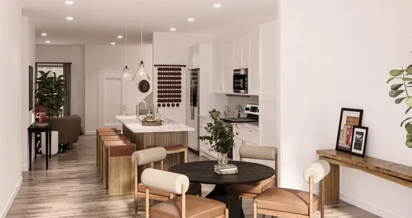 a living room with furniture a wooden floor and a potted plant
