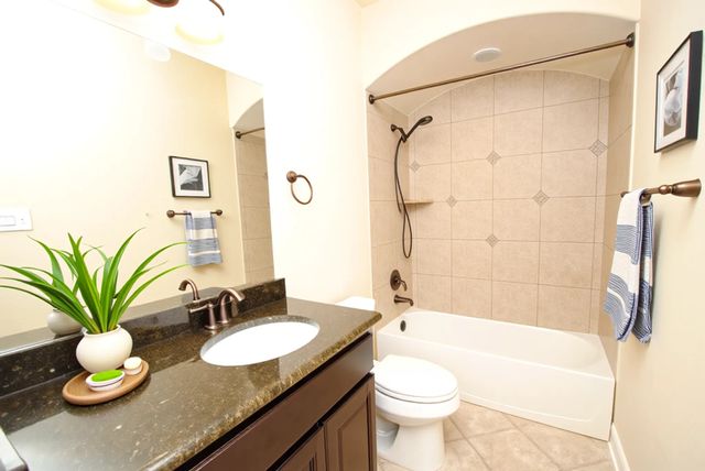 a bathroom with a granite countertop sink toilet and shower
