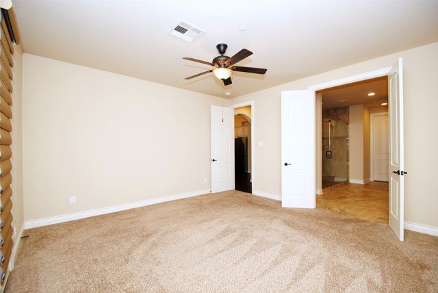 a view of a big room with chandelier fan and windows