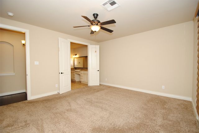 an empty room with closet and ceiling fan