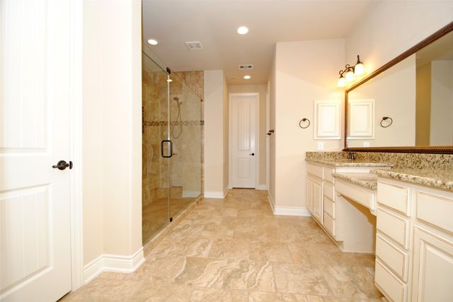 a spacious bathroom with a granite countertop sink mirror and shower