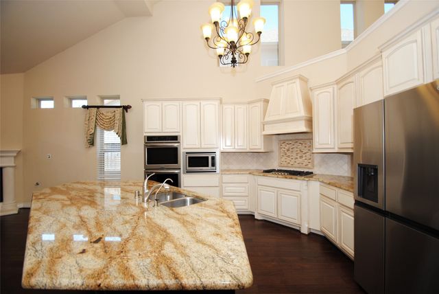 a kitchen with stainless steel appliances a stove sink refrigerator and cabinets