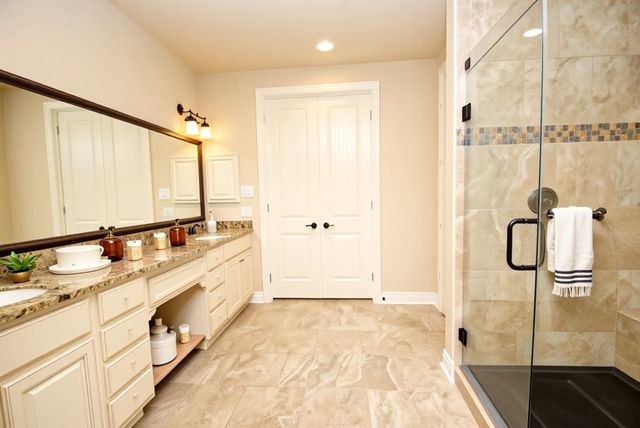 a bathroom with a double vanity sink a mirror and a shower