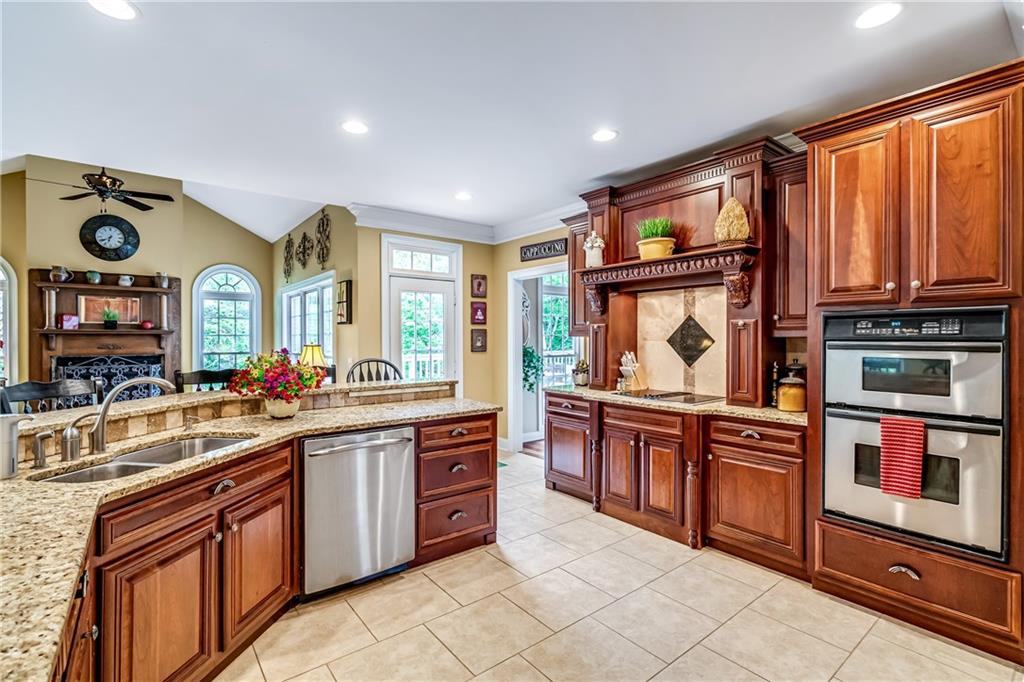 411 Overlook Way Cohutta, GA 30710 - Photo 34 of 86 a kitchen with stainless steel appliances granite countertop a stove top oven a sink dishwasher and cabinets with wooden floor