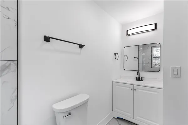 a bathroom with a toilet a sink and mirror