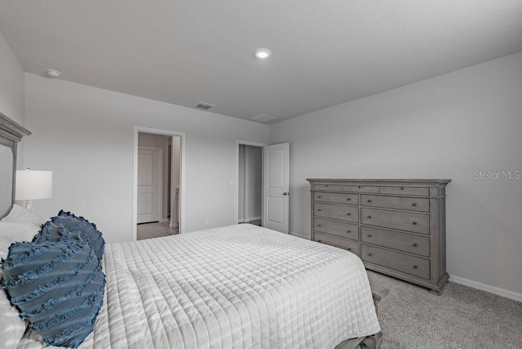 7041 Feather River Place Parrish, FL 34219 - Photo 15 of 32 a bedroom with a bed and a dresser