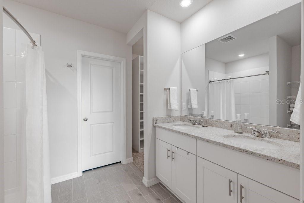 7041 Feather River Place Parrish, FL 34219 - Photo 16 of 32 a bathroom with a granite countertop sink and a mirror