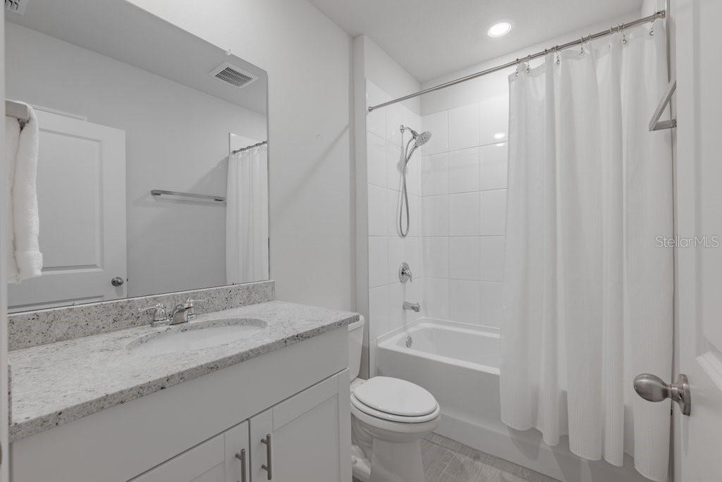 7041 Feather River Place Parrish, FL 34219 - Photo 23 of 32 a bathroom with a granite countertop sink toilet and shower