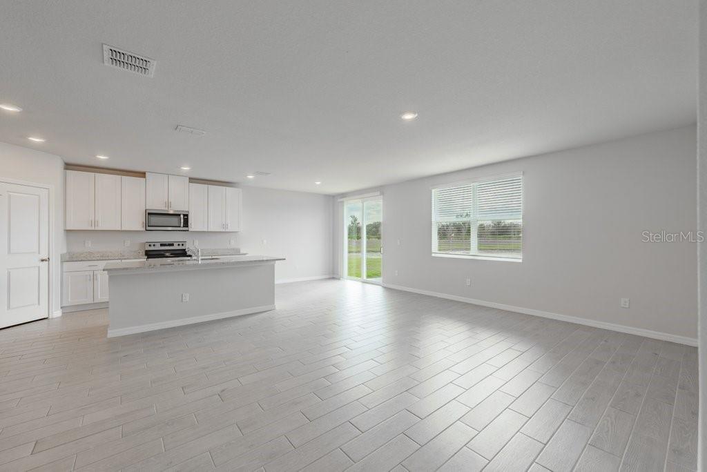 7041 Feather River Place Parrish, FL 34219 - Photo 4 of 32 a view of kitchen with kitchen island white cabinets and stainless steel appliances