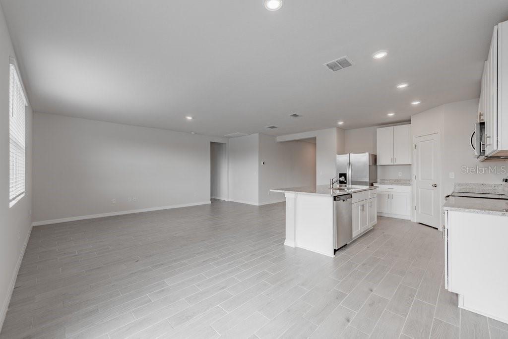 7041 Feather River Place Parrish, FL 34219 - Photo 6 of 32 a view of kitchen with kitchen island white cabinets and refrigerator