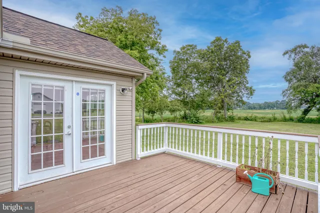 a view of deck with wooden floor and fence next to a yard