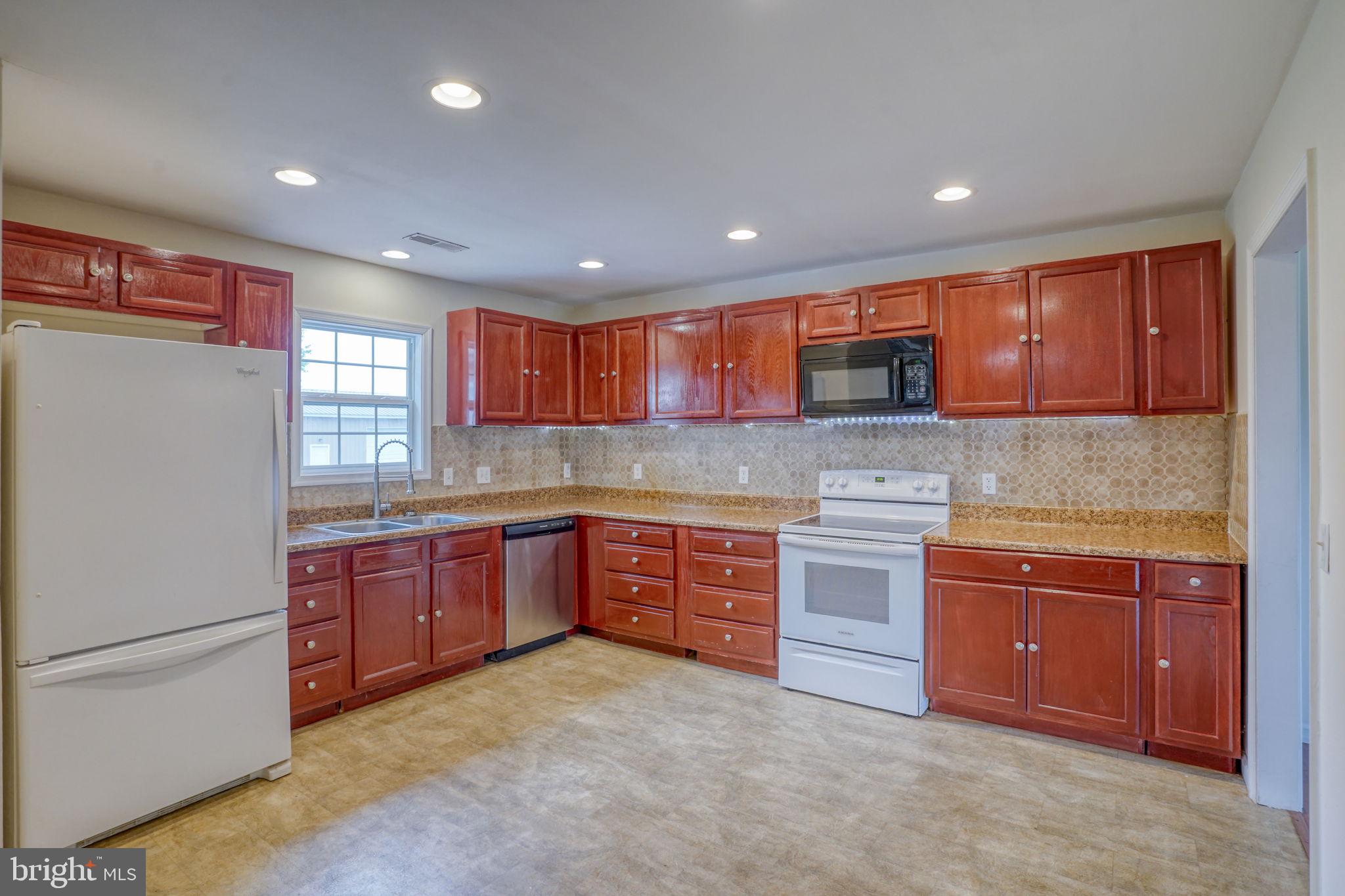 5926 Mt Holly Road East New Market, MD 21631 - Photo 20 of 36 a kitchen with stainless steel appliances granite countertop wooden cabinets a stove top oven a sink and dishwasher