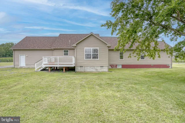 a front view of house with yard and trees in the background