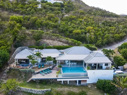 an aerial view of a house with swimming pool garden and patio
