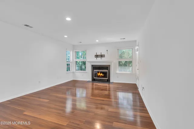 a view of an empty room with a window and fireplace