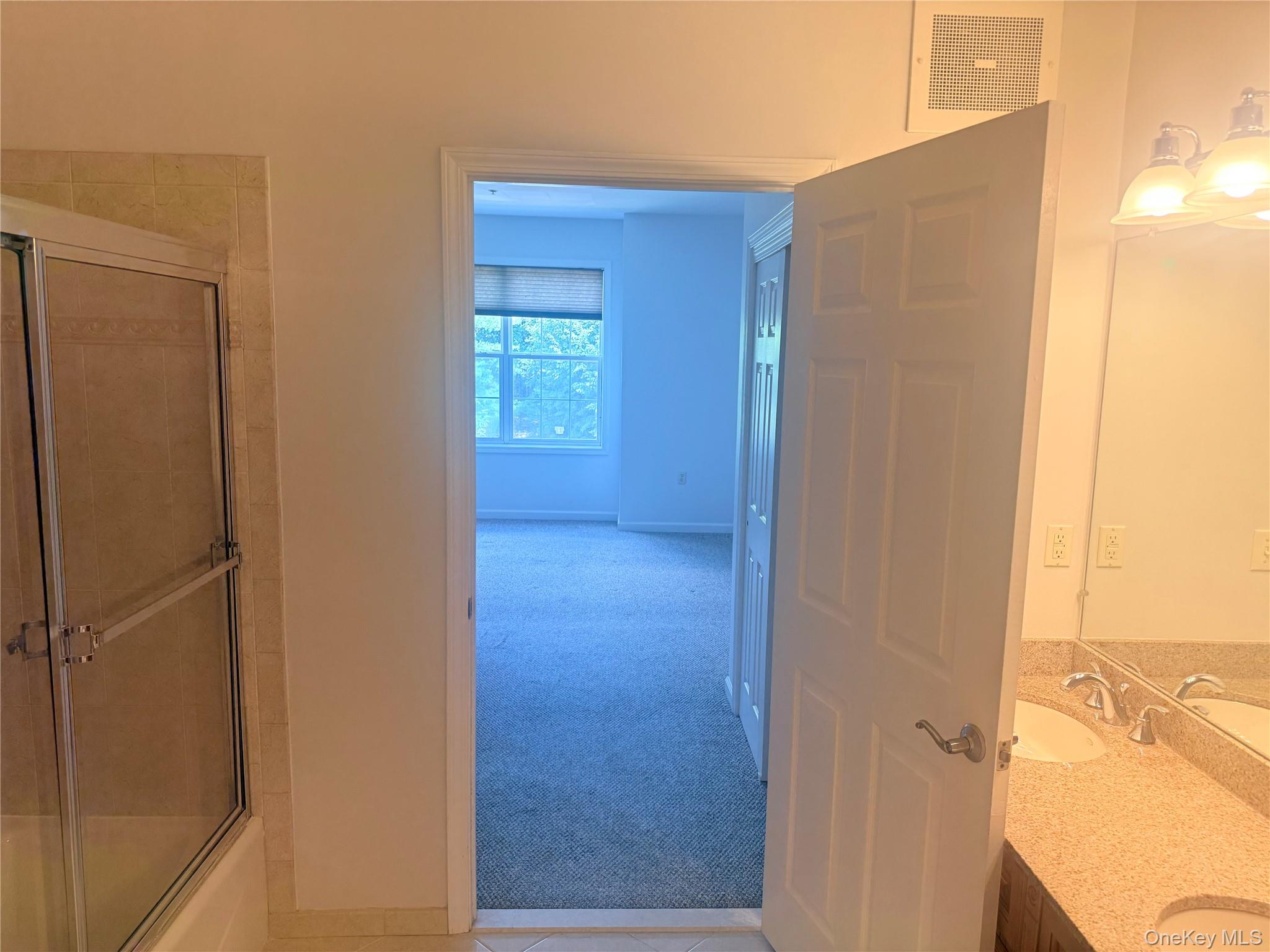 935 Tower Ridge Circle Middletown, NY 10941 - Photo 6 of 24 Bathroom featuring a shower with glass enclosure, dual vanity with light-toned countertop, and mirror