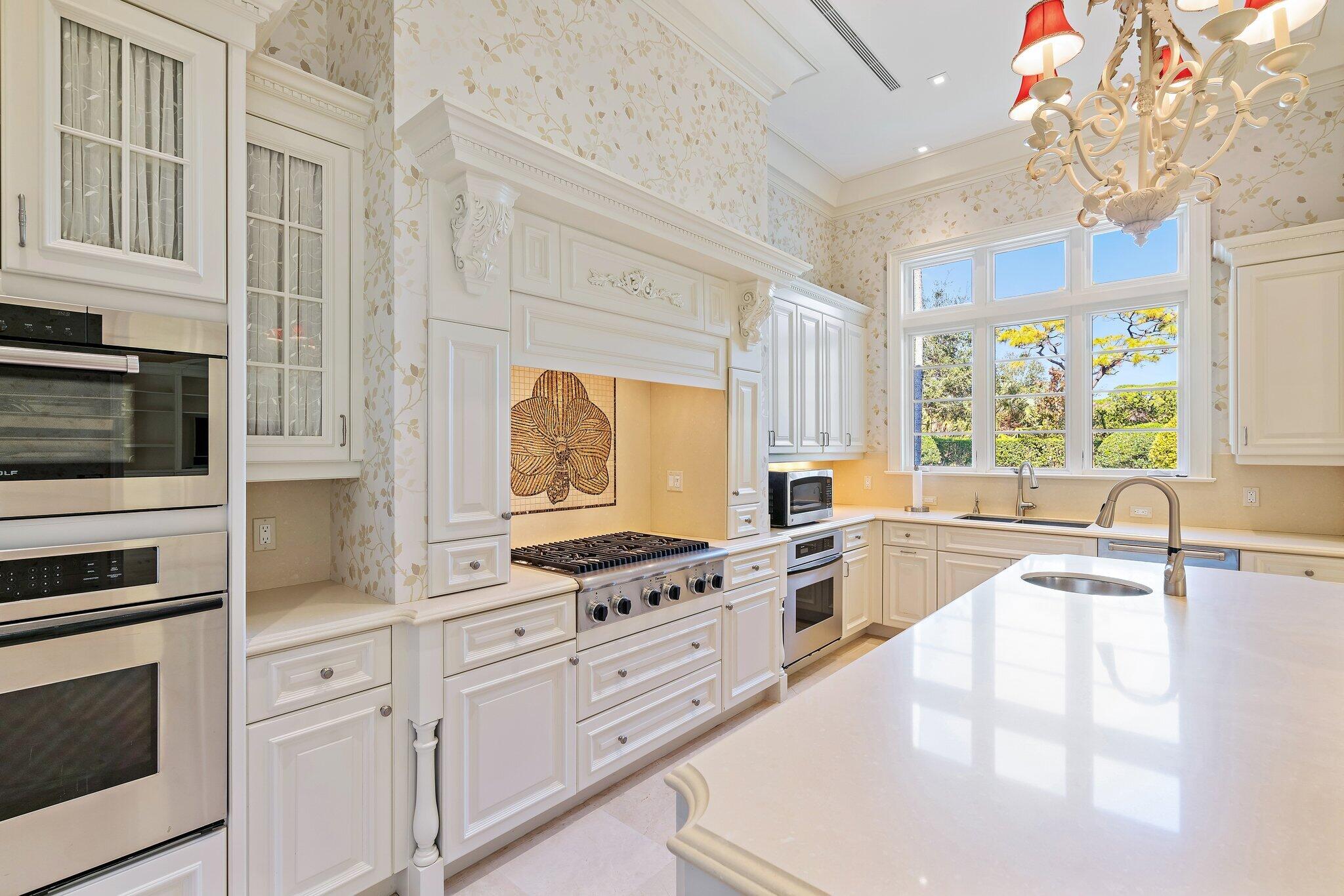 124 Bears Club Drive Jupiter, FL 33477 - Photo 50 of 75 a kitchen with stainless steel appliances a stove sink and cabinets