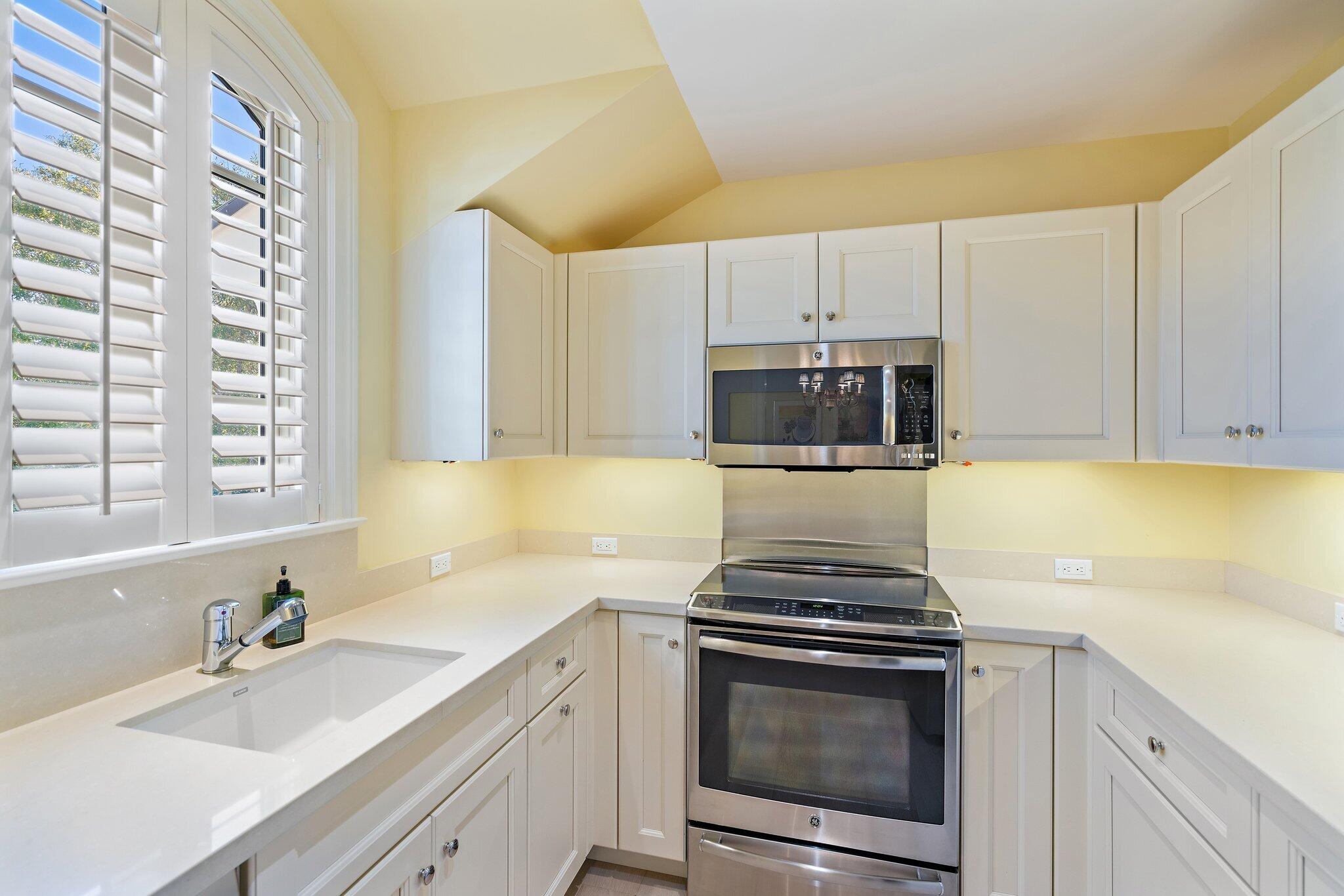 124 Bears Club Drive Jupiter, FL 33477 - Photo 73 of 75 a kitchen with granite countertop a sink stove and cabinets