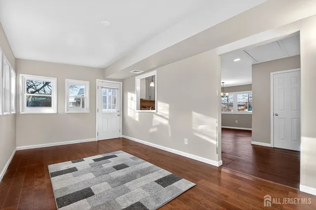 a view of a hallway with wooden floor and a cabinet
