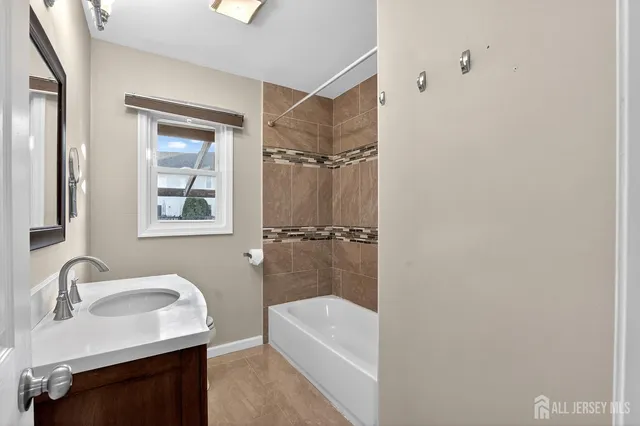 a bathroom with a tub sink and mirror