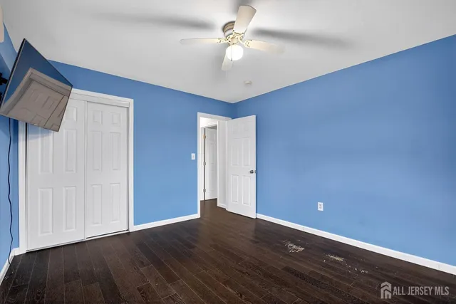 a view of an empty room with window and a ceiling fan
