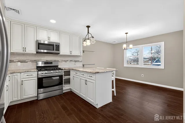 a kitchen with stainless steel appliances granite countertop a stove a sink and a microwave