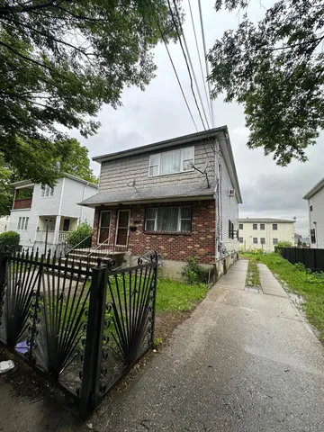 a view of a house with a patio and a yard