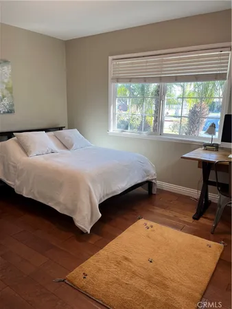 a bedroom with a bed a table and a large window