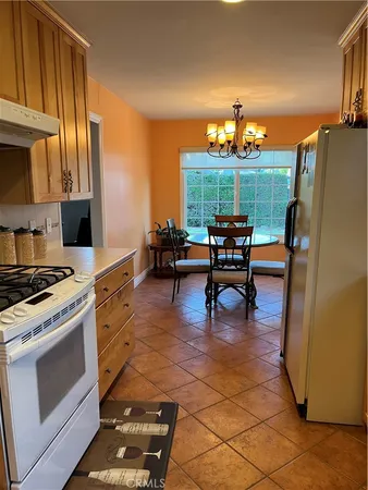 a kitchen with stainless steel appliances a stove a refrigerator and a dining table