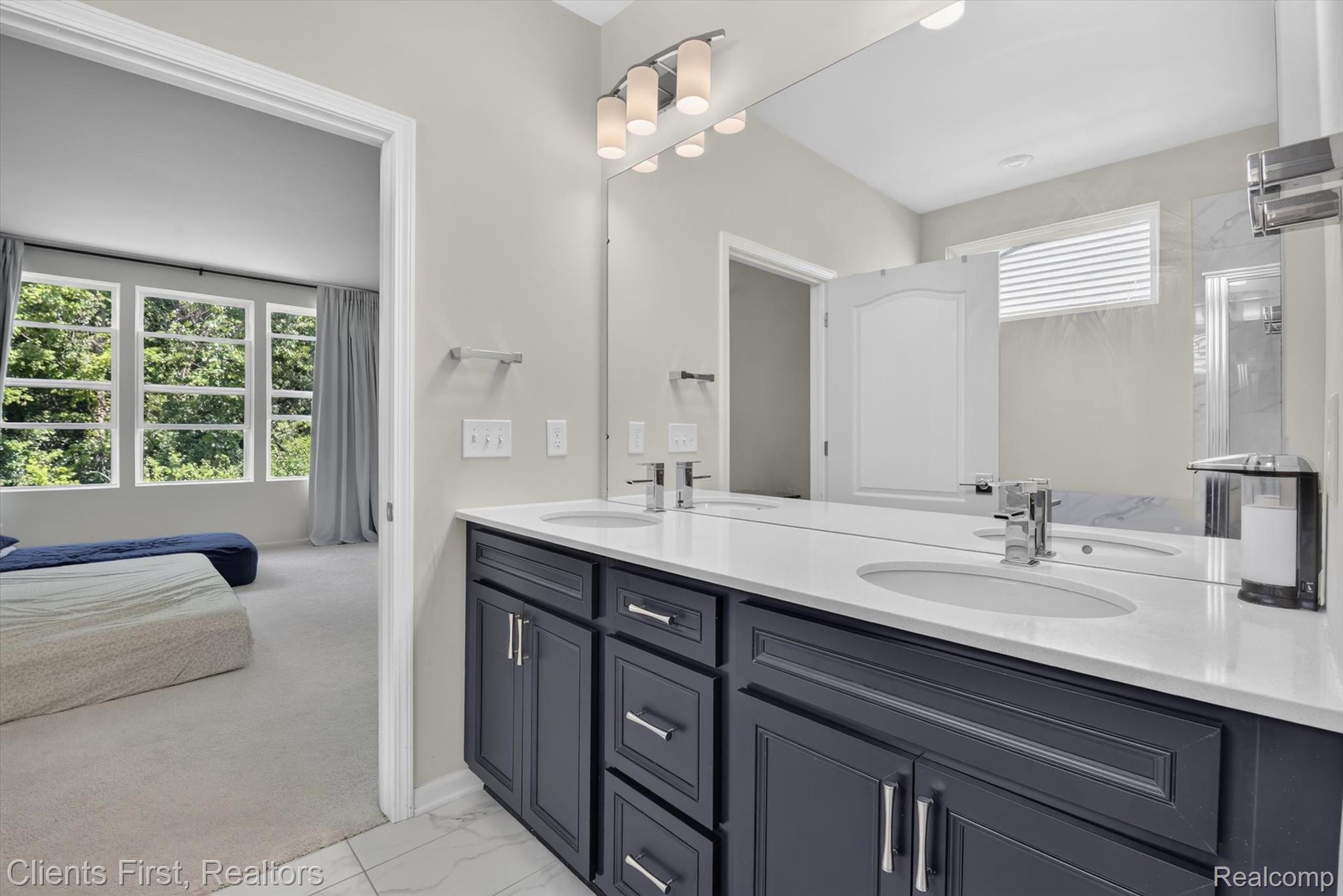 4699 Bingham Road Canton, MI 48188 - Photo 21 of 47 Double vanity featuring dark-toned cabinetry, polished chrome hardware, and a light-toned countertop with integrated sinks