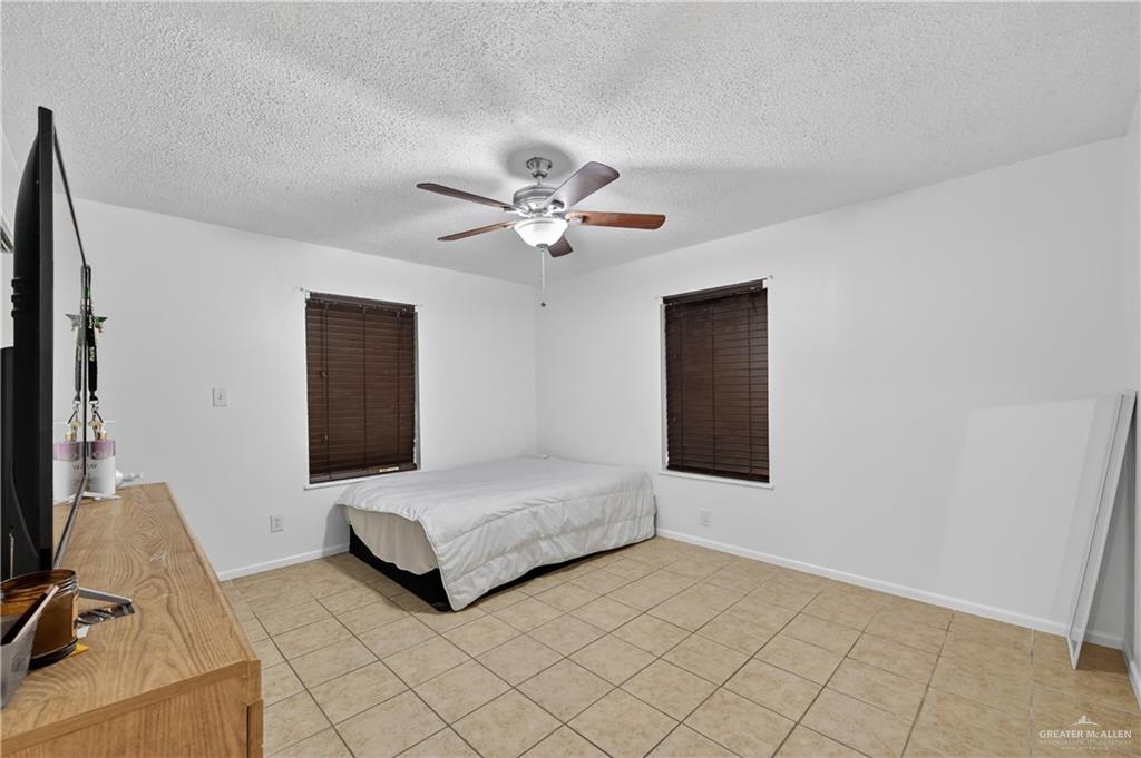 616 5th Street Weslaco, TX 78596 - Photo 33 of 33 a spacious bedroom with a bed and a chandelier