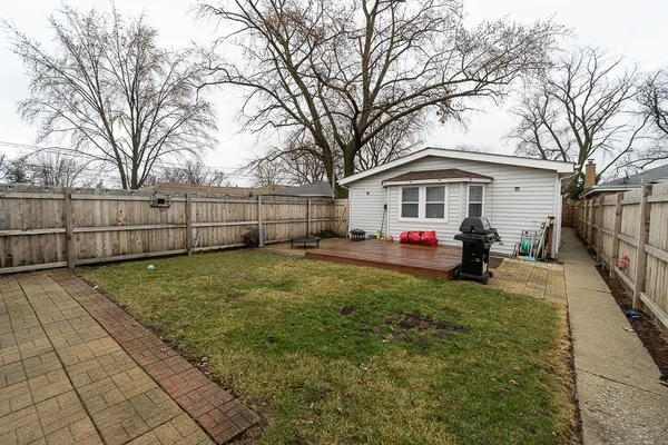 a view of a white house with a large trees and yard