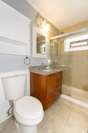 a bathroom with a sink a toilet and shower
