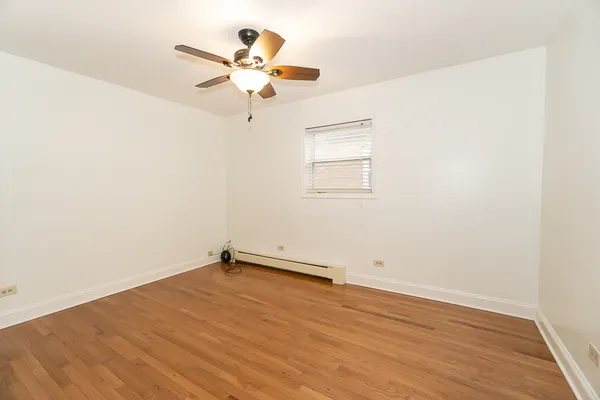 an empty room with a window and a fan