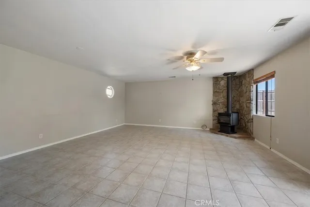 a view of an empty room with a ceiling fan and window