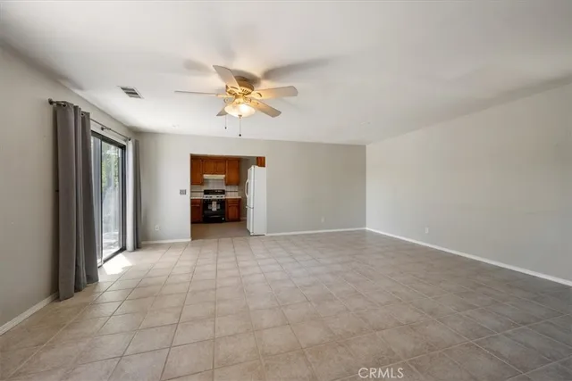 a view of an empty room with wooden floor and windows