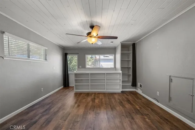 an empty room with windows and fan