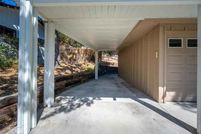 a view of backyard with a trees and wooden fence