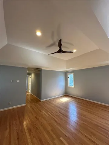 a view of an empty room with window and wooden floor