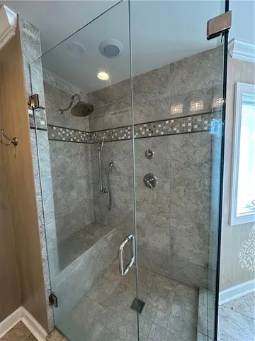 a bathroom with a granite countertop sink a mirror and a shower