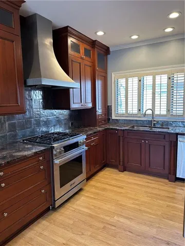a kitchen with stainless steel appliances granite countertop a stove a sink and a microwave