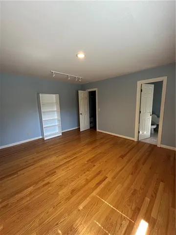 a spacious bathroom with a toilet a sink and mirror