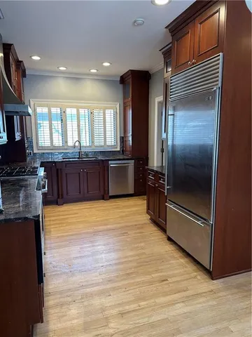 a large kitchen with stainless steel appliances granite countertop a refrigerator and a stove top oven