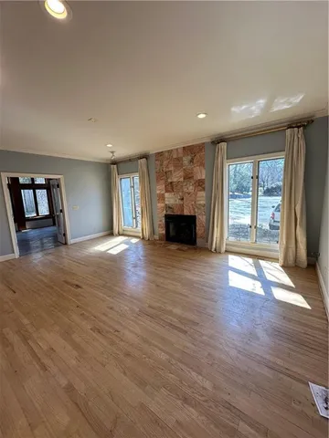 an empty room with wooden floor and fireplace