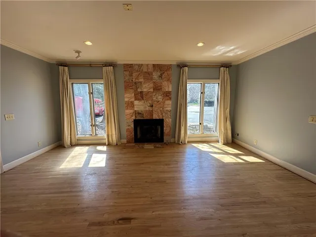 an empty room with wooden floor and fireplace