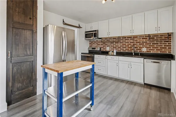 a kitchen with granite countertop a sink stove and refrigerator