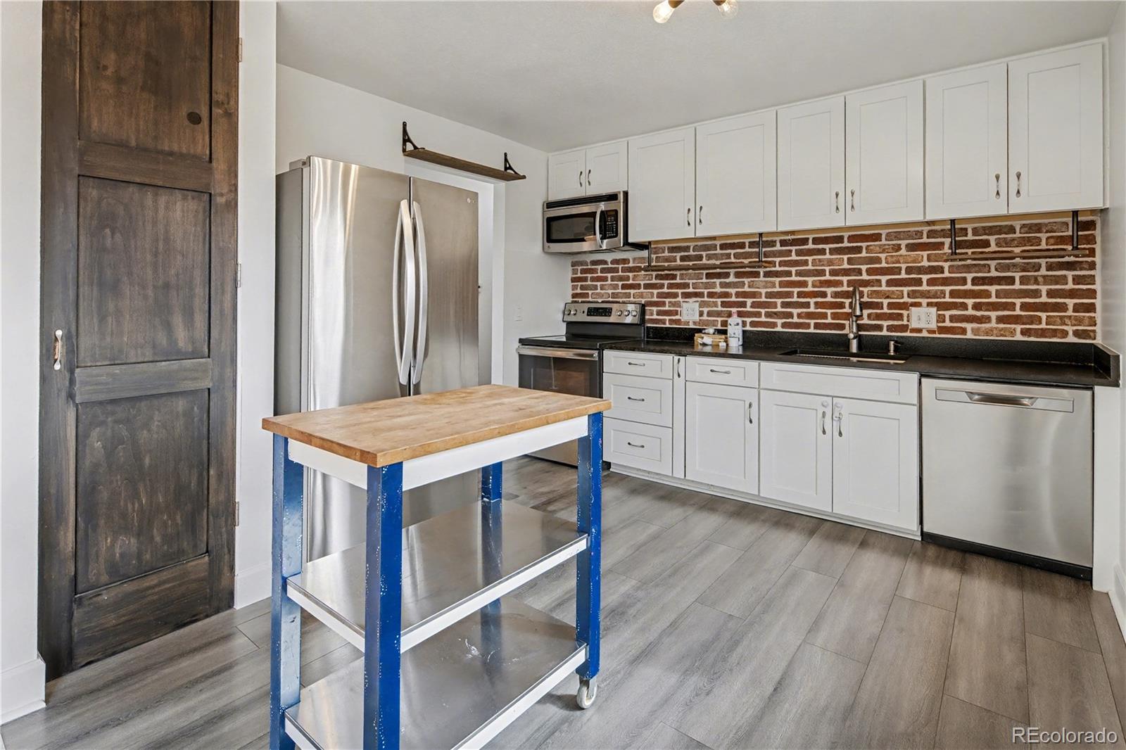 9142 Oberon Road Arvada, CO 80004 - Photo 1 of 35 a kitchen with granite countertop a sink stove and refrigerator